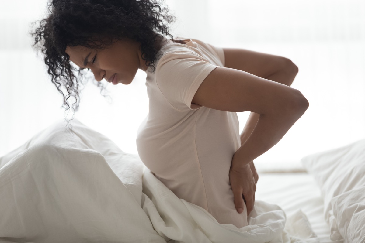 Woman with kidney pain in bed in pain