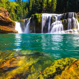turquoise swimming hole with a waterfall