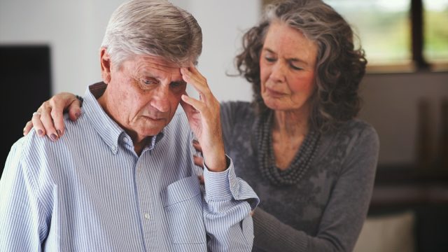 Woman helping man with memory problem at home