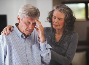 Woman helping man with memory problem at home