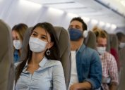 Travelers on a plane wearing face masks during the COVID-19 pandemic