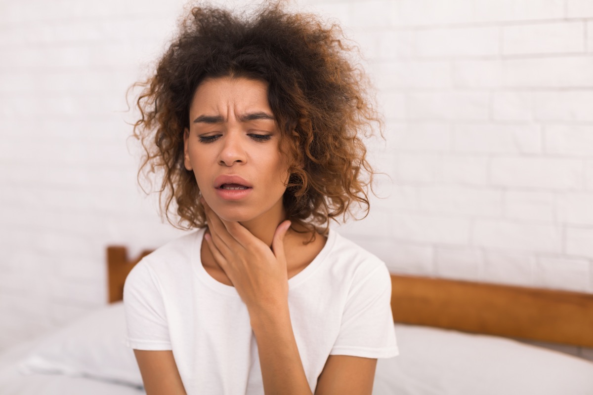 Woman holding her throat because of post nasal drip