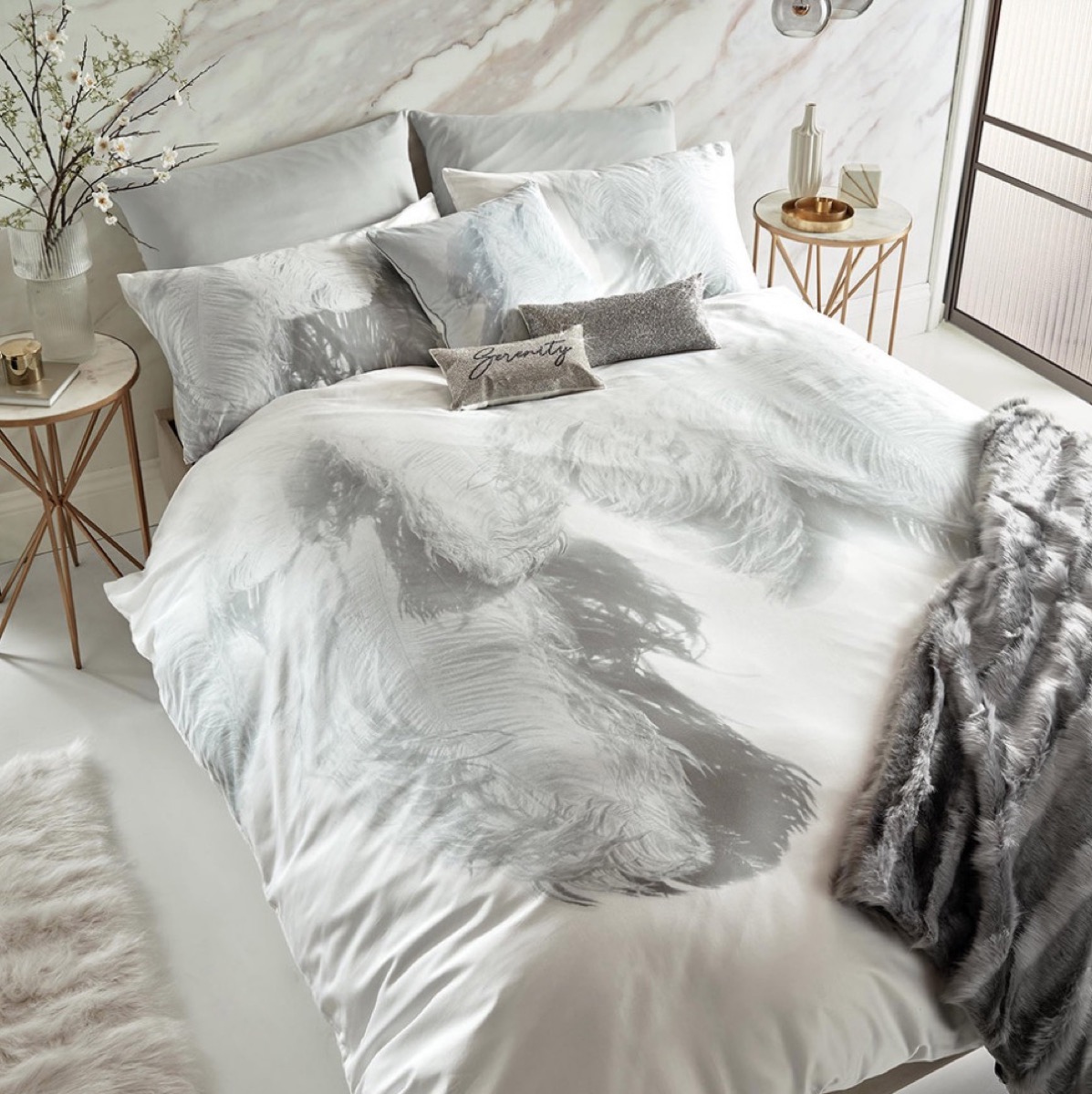 bedroom with white and gray comforter set with feather design