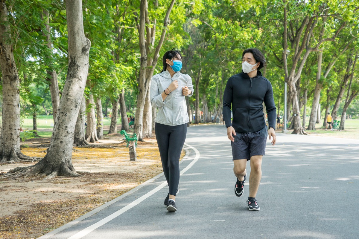 People wearing face masks while running in park