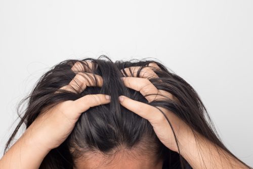 Woman with scalp pain touching hair