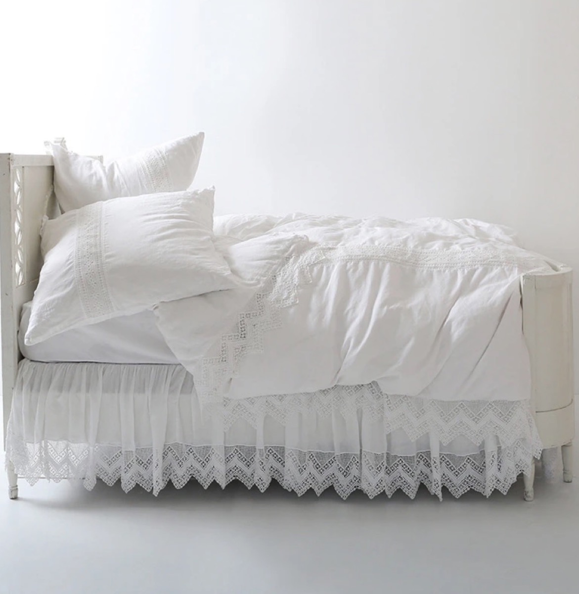 white bed with ruffly bedding