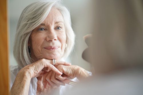 older white woman looking in mirror