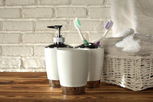 soap dispenser toothbrush holder and towels in bathroom