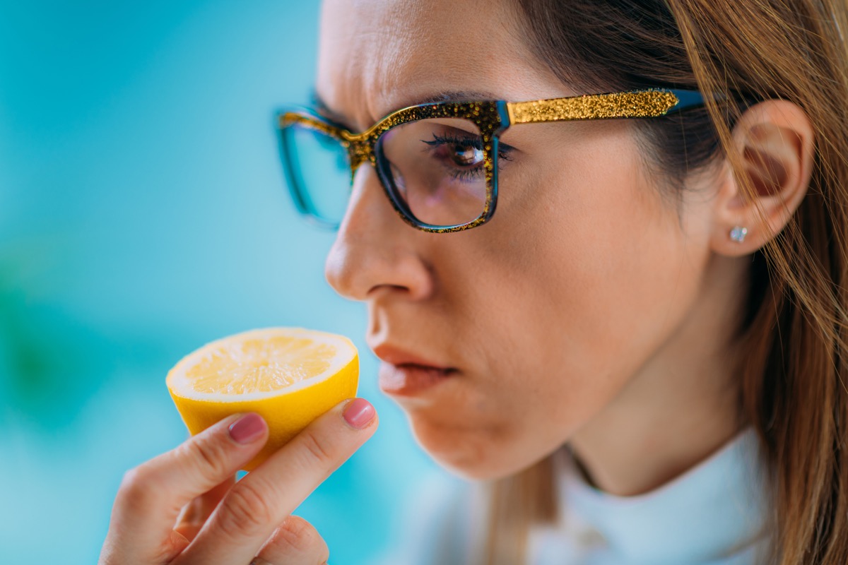 Woman trying to smell lemon lost sense of smell