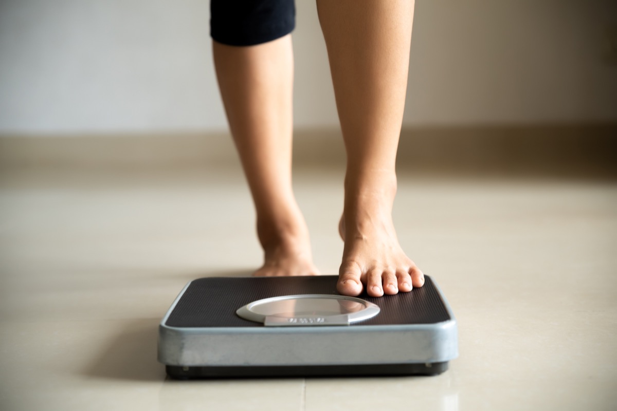 Woman stepping on scale to check weight