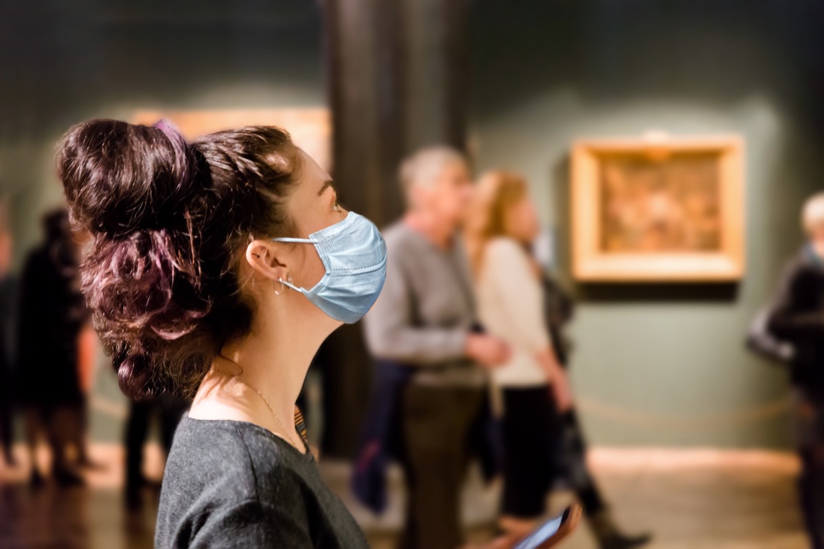A woman in a museum wearing a mask because of Covid