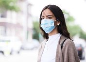 Walking home after class, the young woman wears her protective mask because of the coronavirus epidemic.