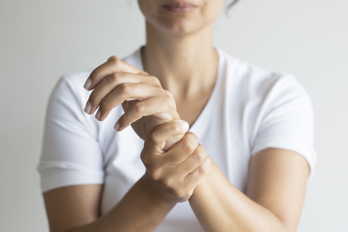 Woman holding wrist from pain