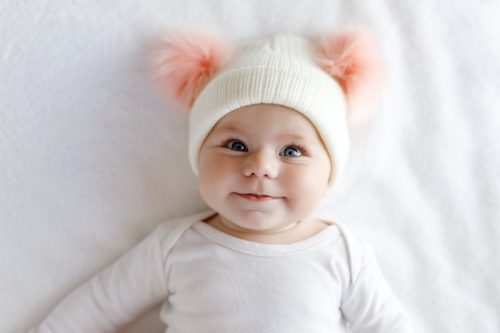 Baby girl in pom pom hat