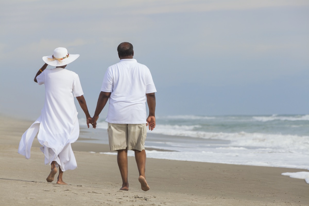 Black senior couple walking on beach