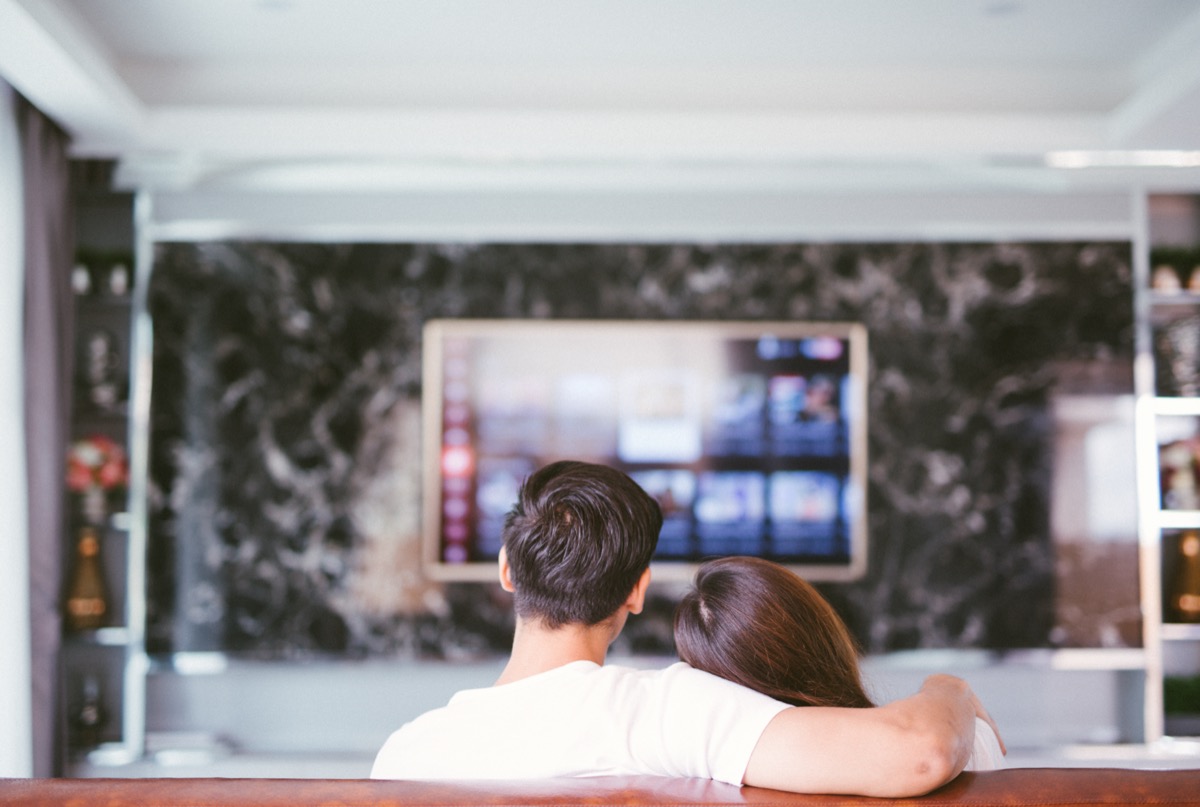 Couple sitting on couch watching movie