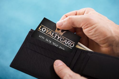 white hand pulling loyalty card out of wallet