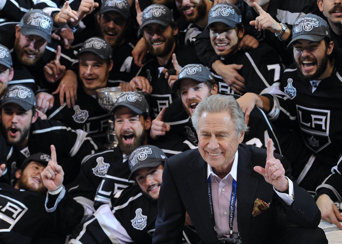 Los Angeles Kings owner Philip Anschutz, right, with his team pose for a group picture after beating the New Jersey Devils 6-1 in game 6 to win the Stanley Cup , Monday, June 11, 2012, in Los Angeles.