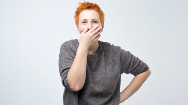 Redheaded woman trying not to laugh