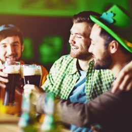 Three young white male friends celebrating St. Patrick's Day in an Irish pub