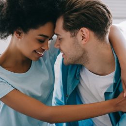 Young Black woman and young white man embracing
