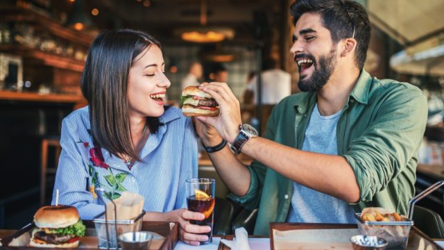 Young couple sharing burgers