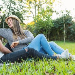Young man and woman laughing together in park