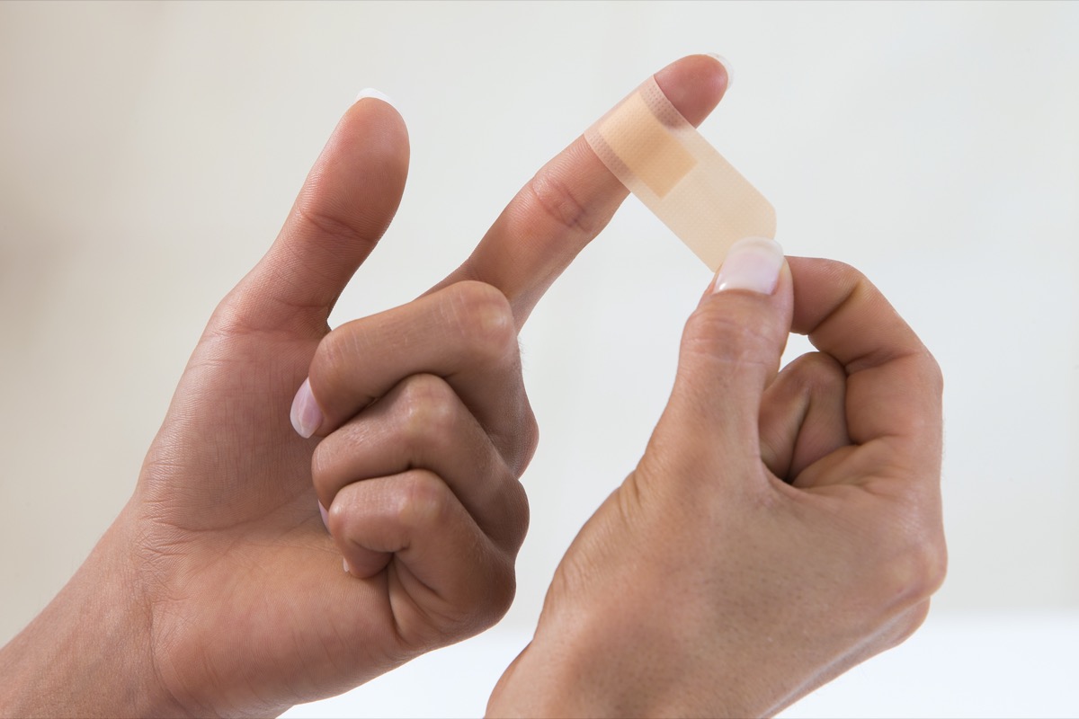 hands applying bandage to finger