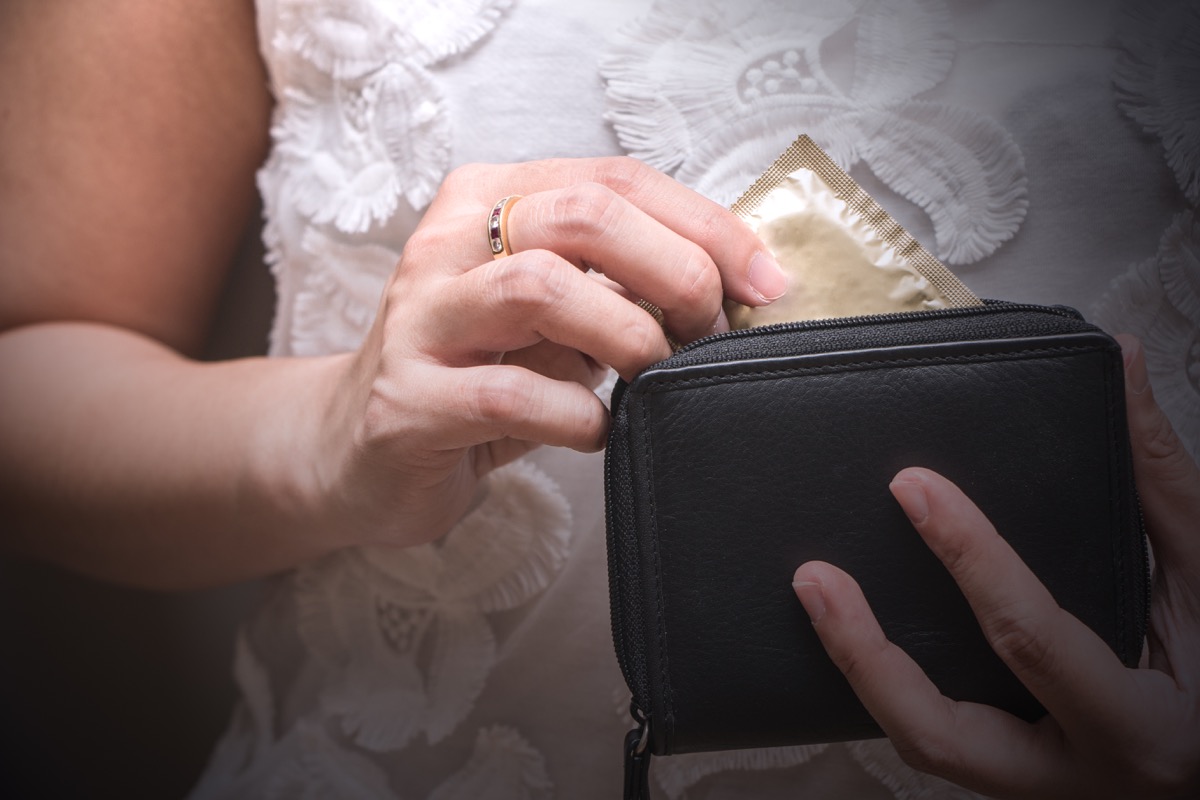 Woman taking a condom out of her wallet