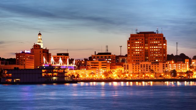 The skyline of Davenport, Iowa at sunset with the Mississippi River in the foreground