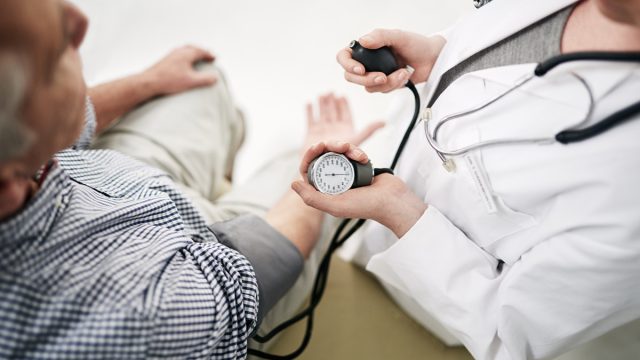 Shot of a doctor checking a senior patient's blood pressure in her office