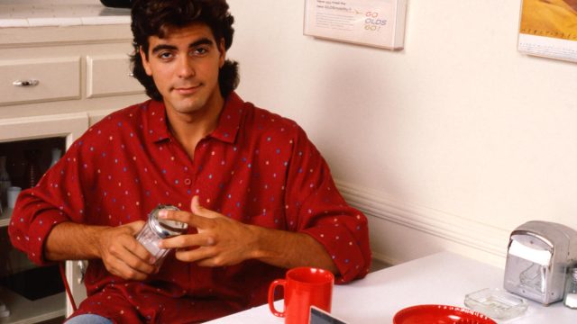 Portrait of George Clooney in a diner, Los Angeles, USA., in the 1980s, holding a sugar shaker