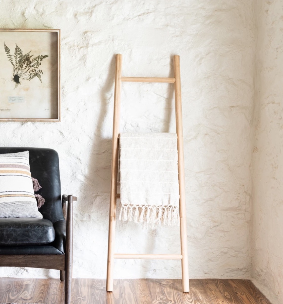 wooden ladder leaning against white wall