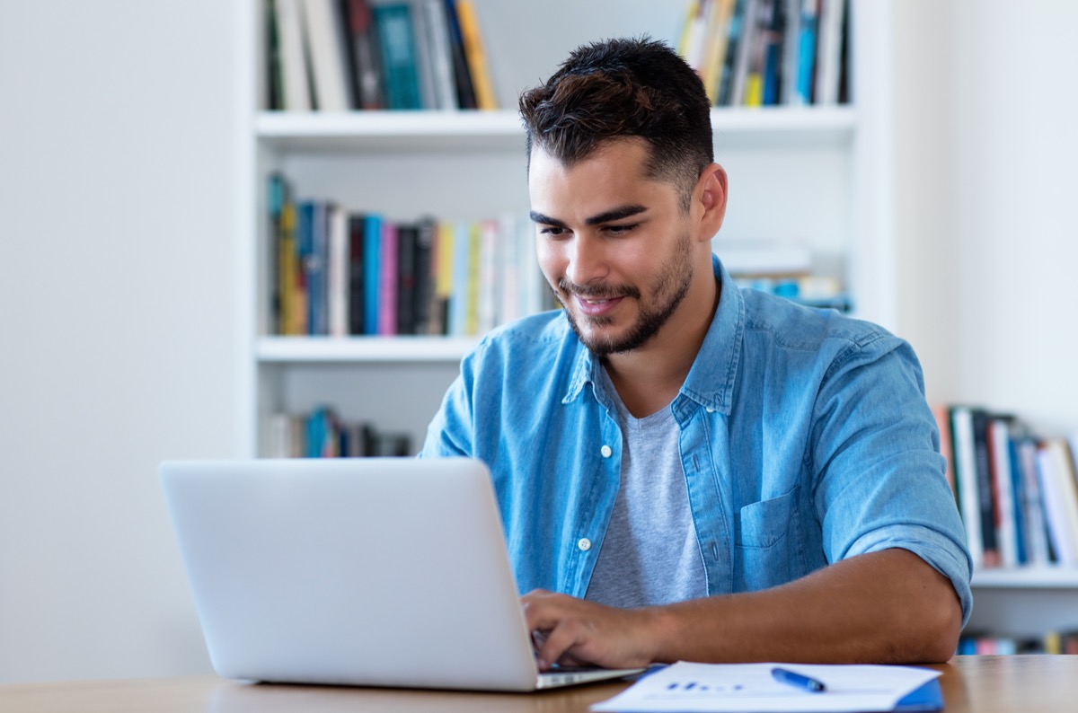 Handsome hipster man sending email with laptop