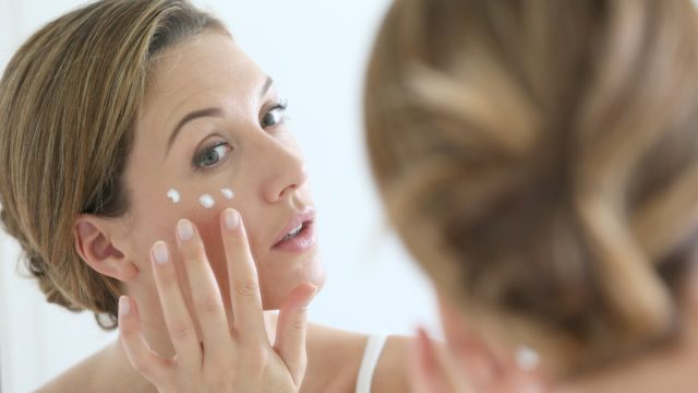 middle aged white woman applying eye cream