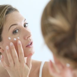 middle aged white woman applying eye cream