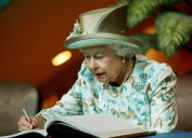 Queen Elizabeth II, 84, of Britain, signs a guest book after she addressed the General Assembly at the United Nations on July 6, 2010 in New York.
