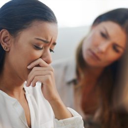 Shot of two young businesswomen talking to each other while being seated in the office at work