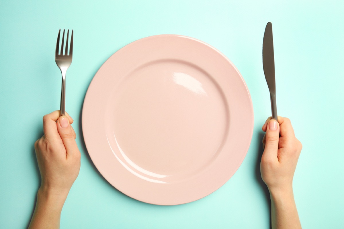 clean pink plate with woman holding a fork and knife