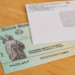 stimulus check and envelope on a wooden table