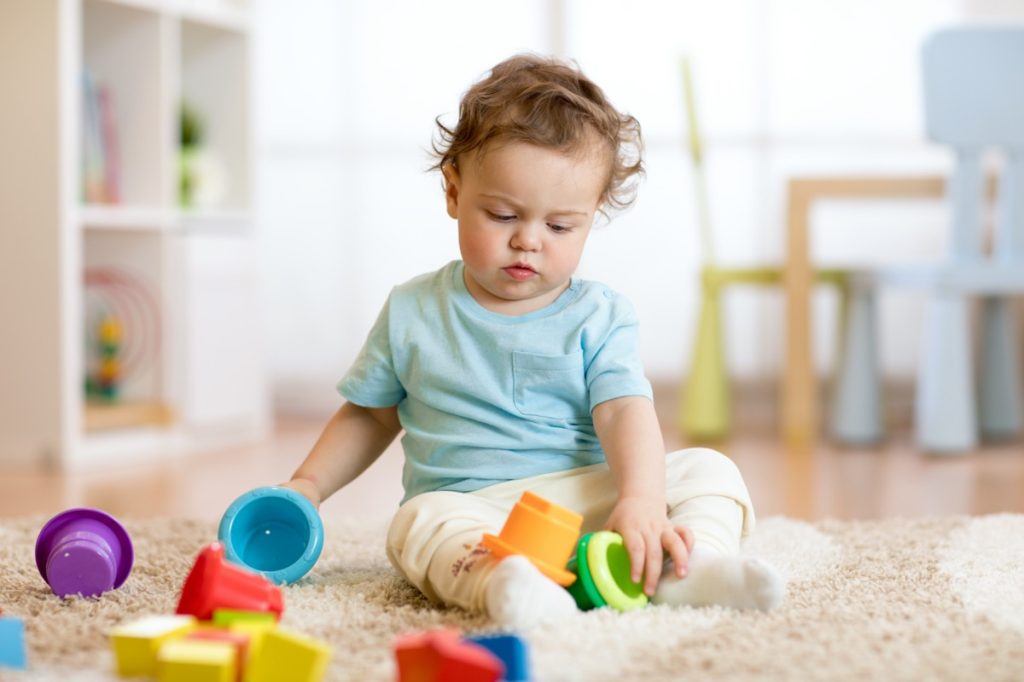 toddler playing with stacking cups