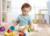 white toddler playing with stacking cups