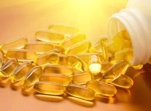 close up of vitamin d capsules spilling out of bottle with sunshine lighting them up