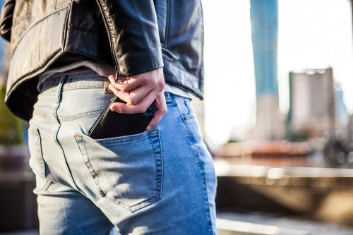 Man putting his wallet in his back pocket