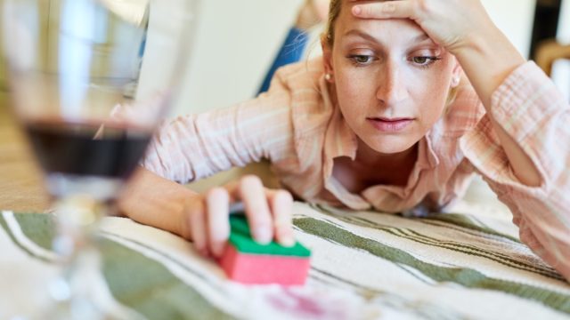 white woman looking annoyed while cleaning fabric with a sponge