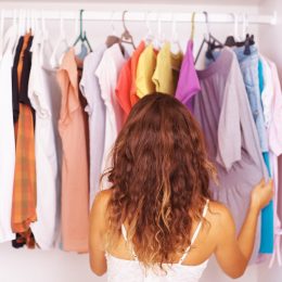 Rear view of a woman going through the clothes in her closet
