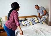 young black couple making bed