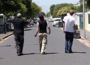 Shot of three young men walking down a suburban street