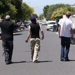 Shot of three young men walking down a suburban street