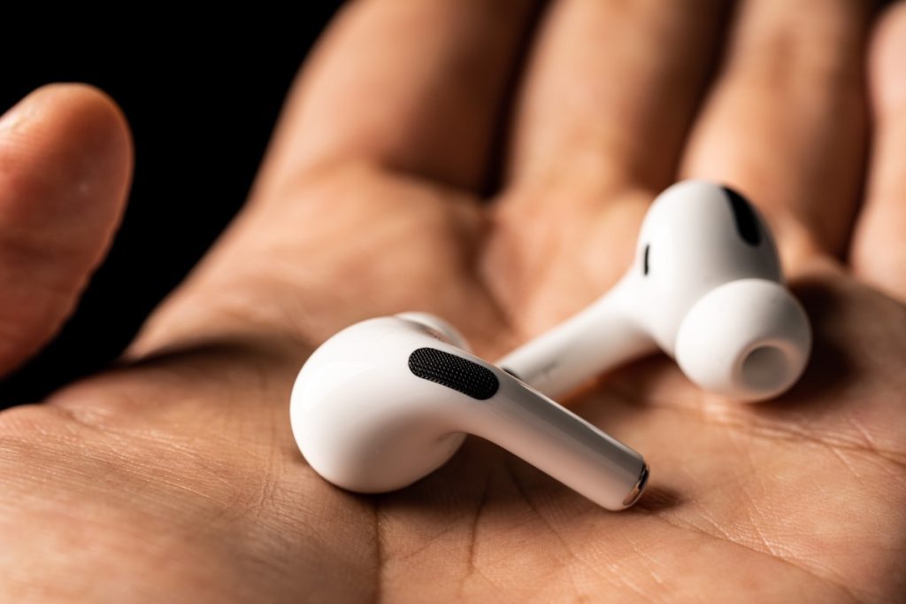 Two airpods in a person's hand